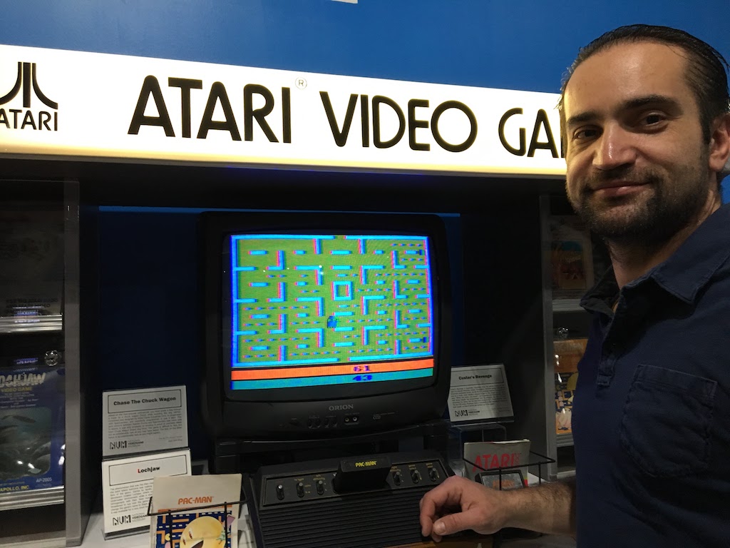 Tarek next to Atari game at National Video Game Museum